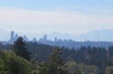 There is a beautiful view of Seattle and the mountains from a nearby street here